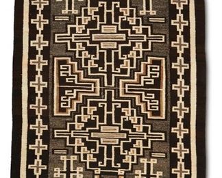 55
Early/mid-20th century; Dine
A Navajo Teec Nos Pos Rug
Woven in brown, grey, tan, and cream wool with central stepped elements and floating geometric motifs with a cross border
68" H x 44" W
Estimate: $1,000 - $2,000