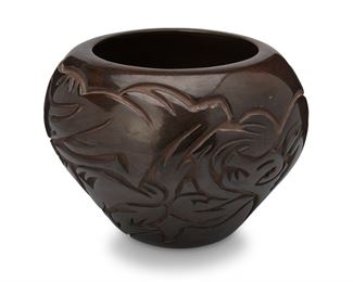 87
Billy Cain (1950-2006, Santa Clara Pueblo)
A carved blackware pottery jar, late 20th century
Signed to the underside: Billy Cain / Santa Clara / Pueblo
The large vessel with burnished black slip glaze and deeply-carved Avanyu motifs throughout
7.25" H x 10" Dia.
Estimate: $300 - $500