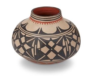 100
Robert Tenorio (B.1950, Santo Domingo Pueblo)
A Santo Domingo Kewa pottery jar
Signed and dated to underside: Robert Tenorio / Kewa / 2001 / [stars]
The polychrome pottery vessel with black geometric band, red scallop motif, and red foot on buff slip glaze
7" H x 9" Dia.
Estimate: $300 - $500