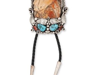113
Late 20th century
A Carved Shell Sterling Silver Bolo
Roughly etched to reverse: FL [possibly for Frank Laheleon; Hopi]; further stamped: Sterling
A large bolo with elaborate foliate silver overlay and set turquoise and coral all framing a carved shell image of a man and horse, with braided leather strap
Bolo: 3.25" H x 2.75" W<br />96.6 grams gross
Estimate: $300 - $500