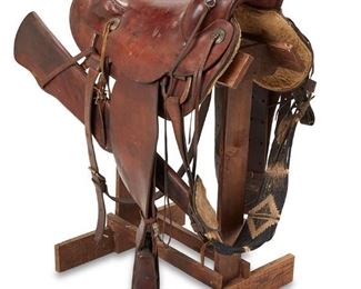 122
Circa 1970s; Eagar, AZ
A Hereford Saddle From John Wayne's Estate, 26 Bar Ranch
Impressed: 972 / 965-7582; With leather badge to underside: J.B. Books
The leather saddle with seat rise, woven billet strap, breast collar, skirt, Hunter rifle holster, and leather stirrups on a wood stand
Horn to cantle: 20.5"; swell width: 12.25"; gullet width: 15.25"; overall on stand: 40" H x 20" W x 27" D
Estimate: $4,000 - $6,000