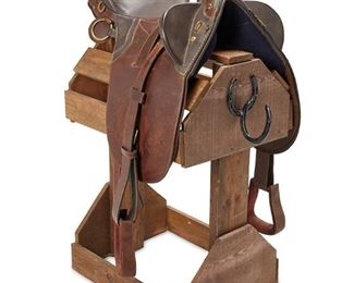 124
Circa 1970s; Eagar, AZ
A Western Saddle From John Wayne's Estate, 26 Bar Ranch
With applied metal badge to cantle: Duke
The leather saddle with seat rise, billet strap, tooled skirt, and leather stirrups on a wood stand
Horn to cantle: 18"; swell width: 16"; gullet width: 14"; overall on stand: 43" H x 22" W x 29" D
Estimate: $2,000 - $3,000