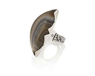 150
21st century; New Mexico, USA
Jared Chavez (B. 1980s; San Felipe Pueblo)
A Puebloan silver and agate ring
Stamped: JC [conjoined] / 925 [to plaque]
Comprising a carved agate and sterling silver ring with incised motifs to squared band
Ring size: 6.5; 2" H<br />32.1 grams gross
Estimate: $500 - $700