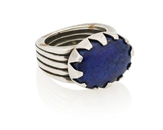 151
21st century
Cody Sanderson (B. 1964, Dine)
A Navajo sterling silver and lapis ring
Stamped: Cody / Santa Fe / Sterling
A Navajo sterling silver ring with large bezel-set lapis stone and ridged band
Ring size: 9<br />21.5 grams gross
Estimate: $300 - $500