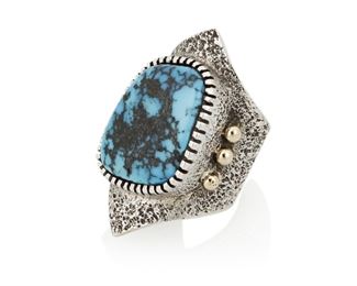 153
Late 20th/21st century
Edison Cummings (B. 20th Century; Dine)
A Navajo turquoise, 14k gold and silver ring
Stamped: E Cummings / 14K
Comprising a chunky tufa cast silver and set turquoise ring with 14k gold ball accents
Ring size: 9.25; 1.625" H<br />33.2 grams gross
Estimate: $400 - $600