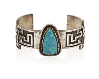 157
Late 20th/21st century
Alvin Tso (B. 20th Century, Dine)
A Navajo sterling silver cuff bracelet
Marked to interior: Alvin Tso / Sterling / [mountain and cloud pictographs]
A heavy sand-cast silver geometric overlay cuff with central tapered turquoise stone set in a raised bezel mount
6.5" total inner C x 1.25" H, with a 1.25" gap<br />66.5 grams gross
Estimate: $200 - $300