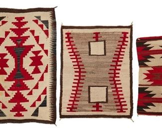 214
Mid-20th century; Dine
A Group Of Navajo Rugs
Comprising three rugs including a small table runner in red, cream, brown and black wool with central serrated diamond (36" H x 17.5" W), a double saddle blanket in red, cream and brown wool with two squares on a cream field with red stepped motifs to sides (42" H x 31.5" W) and a double saddle blanket in brown, cream, red and grey wool with central stepped red diamonds and a fine tooth serrated border (51.5" H x 32.5" W), 3 pieces
Estimate: $500 - $700