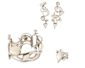 230
Circa 2000
Veronica Poblano (B. 1951, Zuni)
A set of abstract sterling wire and set moonstone and mother of pearl jewelry
Each stamped: Veronica
Comprising a silver wire cuff with swivel clasp closure (6.5" inner C x 2" H), a silver wire ring (Ring size: 8; 1.125" H), and a matching pair of pierced earrings (Each: 2.375" H), 4 pieces
135.2 grams gross
Estimate: $1,200 - $1,800