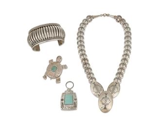 271
Late 20th/21st century
A Group Of Southwest-Style Jewelry
Four works:

A Tommie Charlie Navajo sterling silver ribbed cuff bracelet
(b. 1952, Dine)
Stamped: TC / Sterling
7" total inner C x 1.5" H, with a 1.5" gap

A Carol Felley sterling silver and set turquoise storyteller style reversible pendant with sand-cast Hopi village and dancer to reverse
Stamped: F [for Carol Felly]; further stamped: STER
2.25" H x 1.25" W

A Carol Felley stamped sterling silver turtle pendant/brooch with central set turquoise
Stamped: F [for Carol Felly]; STER / 02
2.25: H x 1.75" W

A sterling silver stamped disk articulated necklace with central oblong disc pendant
Clasp stamped with illegible mark; further stamped: 925
19" L x 1.75" W

4 pieces
194.8 grams gross
Estimate: $200 - $400