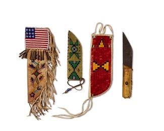 299
Mid/late 20th century
A Group Of Plains-Style Embellished Hide Knife Sheaths
Comprising a beaded hide sheath with green, pink, and dark blue geometric motifs on a yellow field, together with a short knife with hide-covered handle (7" H x 2" W; Knife: 9.5" L), a quilled hide sheath with geometric designs in red, orange, and black (9" H x 3.5" W), and a two-sided pictorial beaded hide knife sheath with foliate motifs and an American flag to each side of flap, finished with fringing to curved edge and tin cones to flap (11" H x 3.5' W; fringing: 3" L), 4 pieces
Estimate: $100 - $200