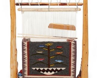 314
Late 20th century; Dine
A Loom With A Navajo Tree Of Life Weaving Sample
Comprised of a loom formed from two natural wood branches, with a Tree of Life weaving sample depicting birds and a Navajo wedding basket and serrated borders, with attached weaving and spinning implements and bowl of wool yarn
21.5" H x 18" W x 3.5" D
Estimate: $200 - $300