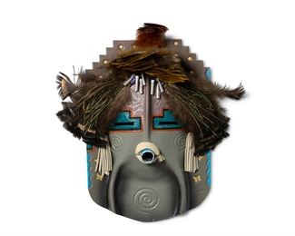 332
Peter Ray James (B. 20th Century, Dine)
A Navajo polychrome pottery wall mask, circa 1998
Stamped to front: PRJ; Further signed verso: Peter Ray James / © / 98
An elaborate Pueblo-style katsina pottery wall mask with grey and polychrome painted and stamped details, various feathers attached to top, leather fringe, and cone dangles
12.375" H x 8.5 " W x 3" H
Estimate: $100 - $200