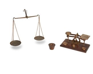 336
19th century
Two Gold Scales
Coin scale marked: Made in England
Two small balancing scales used for measuring coins and gold; one English coin scale complete with nine different weights, both ounces and ounces troy; one partial balancing scale, missing wood base, 11 pieces
Coin scale: 3" H x 7" W; partial scale: 8.5" L x 2.75" W
Estimate: $100 - $200