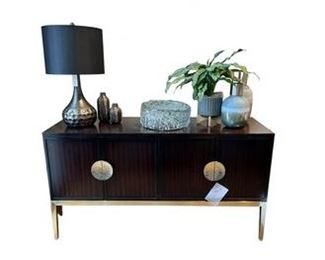 $1985 USD      Bernhardt Jet Set 2 Door Wood Console Cabinet TH154-3       Description: Some living spaces crave a touch of glamour, a burst of energy, or a subtle pop that turns heads.  Combining a fresh sense of style with a nod to the Luxe lifestyle is the goal of Bernhardt’s Jet Set collection.  Classic designs are updated with modern flair—in part from a ‘40s French contemporary influence.  Like a good wardrobe, the pieces are versatile and lend themselves to easy mixing and matching. Accent finishes adorned with solid brass hardware in a golden tone that’s as intricate and unique as fine jewelry. 
Dimensions: 34" H x 63.88" W x 20" D
Condition: New - Interior Design Studio Floor Sample
Local pick up Lake Oswego, OR.  Showroom with main floor access. Contact us for shipper suggestions.      https://goodbyhello.com/products/copy-of-norwalk-whistler-ottoman-thd-02?_pos=9&_sid=f9cbd366d&_ss=r