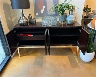 $1985 USD      Bernhardt Jet Set 2 Door Wood Console Cabinet TH154-3       Description: Some living spaces crave a touch of glamour, a burst of energy, or a subtle pop that turns heads.  Combining a fresh sense of style with a nod to the Luxe lifestyle is the goal of Bernhardt’s Jet Set collection.  Classic designs are updated with modern flair—in part from a ‘40s French contemporary influence.  Like a good wardrobe, the pieces are versatile and lend themselves to easy mixing and matching. Accent finishes adorned with solid brass hardware in a golden tone that’s as intricate and unique as fine jewelry. 
Dimensions: 34" H x 63.88" W x 20" D
Condition: New - Interior Design Studio Floor Sample
Local pick up Lake Oswego, OR.  Showroom with main floor access. Contact us for shipper suggestions.      https://goodbyhello.com/products/copy-of-norwalk-whistler-ottoman-thd-02?_pos=9&_sid=f9cbd366d&_ss=r