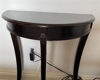 75 - $50 	Small demi lune table black burgundy 24Lx12Dx29H
