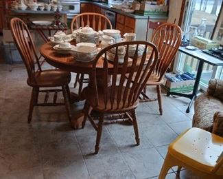 Oak dining table with four chairs and two leaves