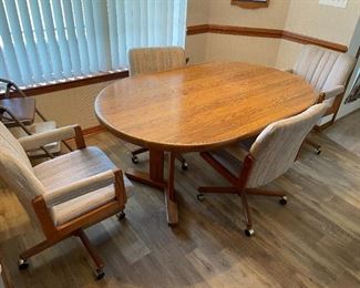 Kitchen table with (4) armed chairs on rollers.                                    65.5"W with leaf 48"W w/o leaf  41.75"D  29"T                                $135.00