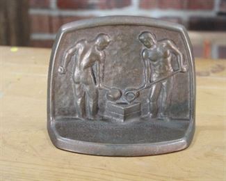 We have two pair of brass or bronze bookends and this one single, showing two men pouring metal into a mould