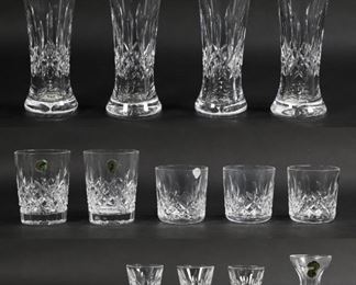 32	15 Waterford Lismore Glasses - 4 Pilsner 3 Tumbler	15 Waterford Lismore crystal glasses -  4 pilsners 8.25", three 8 oz Tumblers 3.25", and two 12 oz Old Fashioneds 4.25", 3 cordials 3.25", one bud vase 4", two shot glasses 2.25"  With paper labels and original boxes. Chip to rim of one cordial. Boxes show wear and staining.
