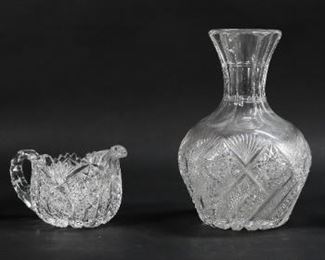 38	4 Pieces Cut Glass	4 pieces cut glass. Vase, 4 1/2"H; creamer, 3 3/8"H; pedestal dish, 3"H; vase, 8 1/4"H. Fleabites throughout all, roughness and chips to rims of small vase, dish and creamer.
