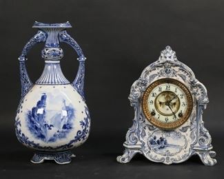 35	Ansonia Delft Royal Bonn Clock & Delft Jug	2 pieces Delft. Ansonia clock in a Delft Royal Bonn porcelain case, blue and white with windmill and leaf designs, 12"H x 10 1/8"L x 4 5/8"W; Delft porcelain two handled jug with ship and castle motif, Delft Etruria mark, 14"H. Line in glaze through center of jug, lines to bottom of jug above base,
