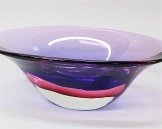91	Art Glass Bowl Tiffany And Company	Purple art glass bowl. Signed Tiffany and Co on bottom. In the style of Josh Simpson. Small scratches around inside of rim, side and bottom. 4 1/2" x 13" x 8"
