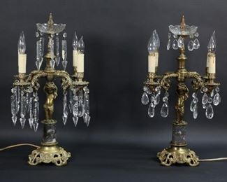 96	Pair of Gilt Bronze & Marble Putto Candelabra	Pair of electrified gilt bronze and marble putti form 4 light candelabra. Each 21"H x 13 1/2"W. Mismatched crystals. Cracks to plastic candle covers on one, bronze  cracked below center bobeche on one, some pitting and white residue present on both.
