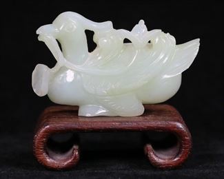 149	Carved Chinese Jade Duck	Chinese carved jade duck. On later wooden stand. Duck 3 1/8"L x 2"H. Chips throughout, including to tail, flowers, feet.

