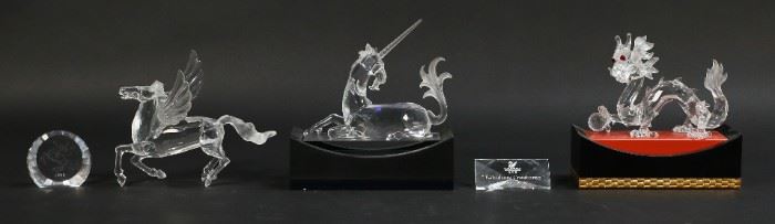 200	Swarovski Crystal 'Fabulous Creatures' Figurines	Set of three Swarovski figurines titled "Fabulous Creatures". Includes dragon with stand, unicorn with stand, Pegasus with matching plaque, and set title plaque. All figures with a Swarovski Swan maker's mark. Stand dimensions: 5 7/8" W x 2 3/4" D x 2" H. Some scratches on black unicorn stand.

