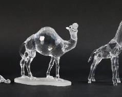 201	Swarovski Crystal African Wildlife Figurines	Lot of seven Swarovski African wildlife figurines. Includes camel, giraffe, cheetah, ibex, alligator, hippo, chameleon, and two small mirrored display plates. All figures with a Swarovski Swan maker's mark. Camel dimensions: 5" W x 1 3/4" D x 4.5" H. Small chip on the tip of the alligator's tail.
