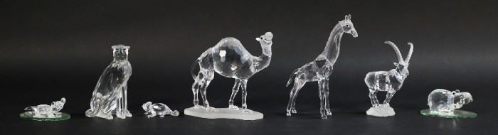 201	Swarovski Crystal African Wildlife Figurines	Lot of seven Swarovski African wildlife figurines. Includes camel, giraffe, cheetah, ibex, alligator, hippo, chameleon, and two small mirrored display plates. All figures with a Swarovski Swan maker's mark. Camel dimensions: 5" W x 1 3/4" D x 4.5" H. Small chip on the tip of the alligator's tail.

