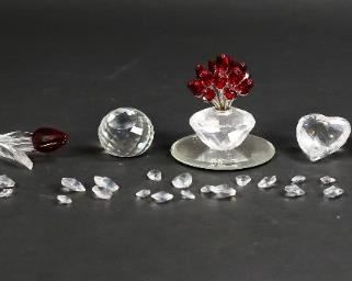 204	Lot of Swarovski Crystal Figurines	Lot of Swarovski crystal figurines. Includes 34 miniature crystal hearts, a blue heart, a red heart, a  white heart, a red tulip, a blue tulip, a logo crystal, and a vase of roses with matching mirrored display plate. All non-miniature figurines include a Swarovski swan marker's mark. Vase of roses measures 2" W x 2" D x 3" H.
