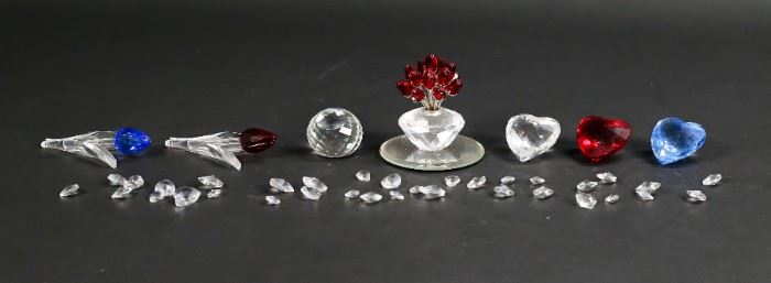 204	Lot of Swarovski Crystal Figurines	Lot of Swarovski crystal figurines. Includes 34 miniature crystal hearts, a blue heart, a red heart, a  white heart, a red tulip, a blue tulip, a logo crystal, and a vase of roses with matching mirrored display plate. All non-miniature figurines include a Swarovski swan marker's mark. Vase of roses measures 2" W x 2" D x 3" H.
