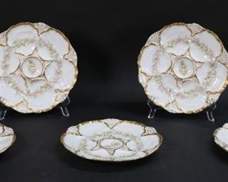 246	Set of 5 Charles Ahrenfeldt Limoges Oyster Plates	Set of 5 Limoges porcelain oyster plates. Floral decoration with gilt rims. Green Charles Ahrenfeldt CA France Depose and CA Limoges France marks to undersides. Each 8 3/4"-diameter. Minor losses to gilt decoration, pinhole sized imperfection in glaze on one.
