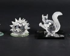 250	Lot of 15 Swarovski Crystal Animals and Flowers	Lot of six Swarovski garden creature figurines and nine flowers. Includes hedgehog, mouse, bunny, squirrel, frog, SCS squirrel with matching display plate, two daisies, seven miniature flowers, and four supplementary mirrored display plates. Figurines include Swarovski swan and S maker's marks. SCS squirrel measures 2 3/4" W x 1 1/8" D x 2 1/4" H. The display plate for the SCS squirrel has a chip on the left hand side.
