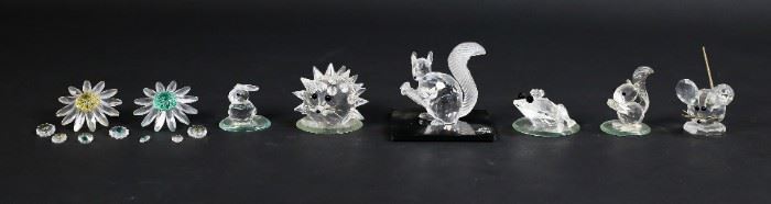 250	Lot of 15 Swarovski Crystal Animals and Flowers	Lot of six Swarovski garden creature figurines and nine flowers. Includes hedgehog, mouse, bunny, squirrel, frog, SCS squirrel with matching display plate, two daisies, seven miniature flowers, and four supplementary mirrored display plates. Figurines include Swarovski swan and S maker's marks. SCS squirrel measures 2 3/4" W x 1 1/8" D x 2 1/4" H. The display plate for the SCS squirrel has a chip on the left hand side.
