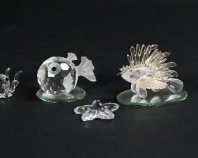 251	Swarovski Crystal Sea Creature Figurines	Lot of nine Swarovski crystal figurines. Includes a lion fish, a puffer fish, 2 octopus, starfish, a crab, a pair of sea turtles, a snail shell, and two mirrored display plates. All figurines include a Swarovski swan or block logo maker's mark. Puffer fish measures 2 3/4" W x 2 1/4 D x 1 5/8 H.
