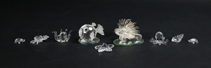 251	Swarovski Crystal Sea Creature Figurines	Lot of nine Swarovski crystal figurines. Includes a lion fish, a puffer fish, 2 octopus, starfish, a crab, a pair of sea turtles, a snail shell, and two mirrored display plates. All figurines include a Swarovski swan or block logo maker's mark. Puffer fish measures 2 3/4" W x 2 1/4 D x 1 5/8 H.
