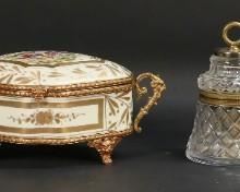 260	4 Crystal & Porcelain Dresser Boxes	Lot of 4 dresser / jewel boxes. 2 crystal boxes with brass mounts, 2 hand painted FBS continental porcelain boxes with scenic lids and brass mounts. Bell shaped crystal box 5 1/2"H, larger porcelain box 9 1/2"L x 4 1/4"H. Flake on interior rim of lid on rectangular crystal box, losses to hand painted decoration on both porcelain boxes, glue residue and discoloration around interior of lids and rims on both porcelain boxes, mount and lid of larger porcelain box detached from box.
