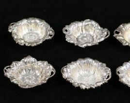 267	Reed & Barton and Gorham Sterling Repousse Dishes	8 sterling silver dishes with repousse floral decoration. Gorham dish, 6"-diameter; set of 6 Reed & Barton nut dishes, each 3 1/2"W; single Reed & Barton nut dish, 3 1/2"W. 272 grams total.
