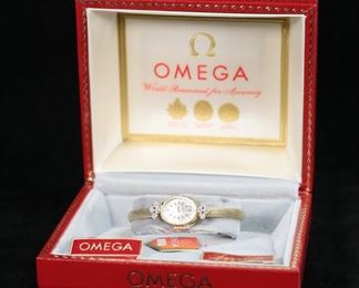 296	Omega Sapphette 14k Gold & Diamond Watch	Omega Sapphette ladies wrist watch. 14k gold with 8 .03125 carat diamonds. Interior diameter 2". Case and clasp marked 14k. With original box. Some wear to exterior box. 18 grams total weight.
