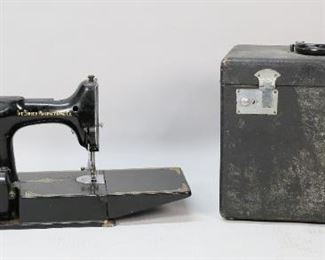 298	Singer Featherweight 221 Sewing Machine in Case	Circa 1950s Singer Featherweight model 221 sewing machine. Serial number AL426469. With foot pedal and case. Machine 15"L. Machine and foot pedal untested. Wear to case and light scratches to machine.
