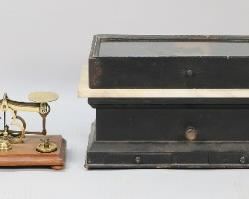 303	Lot of Scales & Weights	Lot of scales and weights including brass and wood balance scale with partial set of weights, wood and marble apothecary scale with glass lid, set of weights on wooden block (missing two smallest weights), set of weights in wooden case 200 grams - 1 gram. Apothecary scale with case 14 1/8"L x 7"W x 7 3/8"H. Wear to wood on all, chip to one corner of marble on apothecary scale, losses to stain on case of apothecary scale and sticker residue on glass.
