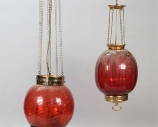 325	2 Cranberry Glass Hanging Fixtures	2 cranberry glass and brass hanging fixtures. Larger with E. Miller kerosene fitting (electrified). Larger 14 1/4"L from top of shade to lower finial. Chips along lower rim on small fixture.
