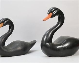 423	Pair of Carved Wooden Black Swans	"Pair of painted black swans with glass eyes and wood beak.  18"" x 13.5"" tall and  21"" long x 17"" tall. Some dents and staining to wood. Some paint marks and denting to wood.
"
