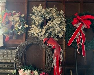 Numerous outdoor wreaths. Some are flocked, and some are grapevine.