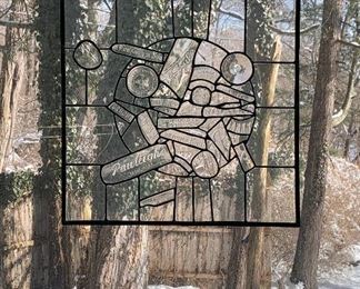 bottle names incorporated in glass art with trees in yard behind