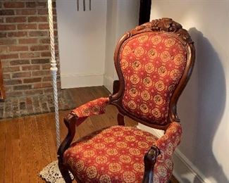 Red Victorian slipper chair with charming iron lamp, wicker shade