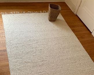 Off-white rag rug, basket shown for scale